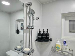 a bathroom with a shower with bottles on a shelf at 행궁동-House2 in Suwon +20 photos