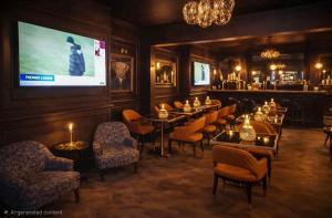 a restaurant with tables and chairs and a projection screen at Hotel Eighteen92 in Liverpool