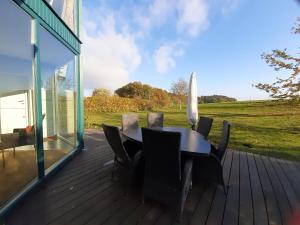 a wooden deck with a table and chairs on it at Ferienhaus Sonnenpier in Putbus +7 photos