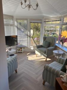 a living room with two couches and a tv at 4 Glenfalloch Road in Crianlarich