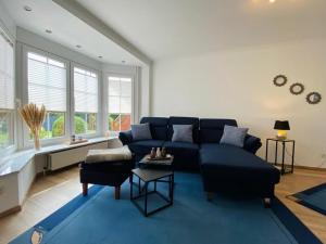 a living room with a blue couch and a blue rug at Ferienwohnung Wellenkamp in Itzehoe