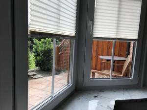 two windows in a room with a view of a patio at Ferienwohnung Wellenkamp in Itzehoe +13 photos
