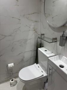 a white bathroom with a toilet and a sink at 4 Glenfalloch Road in Crianlarich