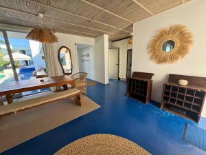 a living room with blue floors and a table and a mirror at Surfers Spot in Ponta do Ouro