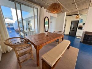 a dining room with a table and chairs and a mirror at Surfers Spot in Ponta do Ouro +17 photos