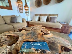 a living room with a couch and a book on a table at Surfers Spot in Ponta do Ouro