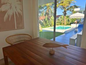 a dining room table with a view of a pool at Surfers Spot in Ponta do Ouro