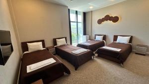 a room with three beds and a flat screen tv at Arena Hotel Yardimli in Kabakhdibi