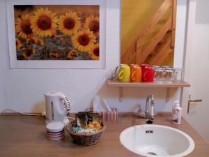 a bathroom with a sink and a picture of sunflowers at B&B Vincent's Attic in Ede