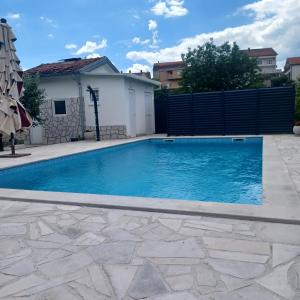 a swimming pool in a backyard with a fence at Apartman Katić - Rental Home in Stolac