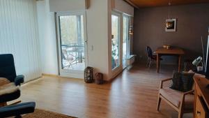 a living room with a wooden floor and a table at Ferienwohnung Am Hummerstein in Ebermannstadt
