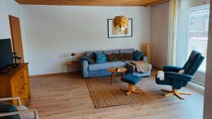 a living room with a blue couch and a chair at Ferienwohnung Am Hummerstein in Ebermannstadt
