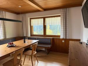 a dining room with a wooden table and chairs at Ferienhaus Riedberg in Ried im Zillertal