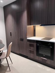 a kitchen with wooden cabinets and a table and a chair at East Apartment in Egilsstaðir +11 photos