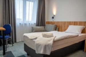 a hotel room with a bed and a chair at Zielony Dworek in Kraśnik