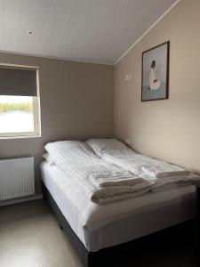 a bed in a bedroom with a picture on the wall at East Apartment in Egilsstaðir