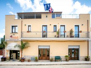 a building with a flag on top of it at Triskell Camere & Relax in Castelluzzo