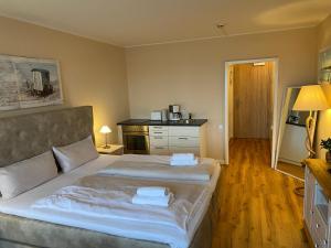 a bedroom with a large bed and a kitchen at Fördeblick Anna in Glücksburg