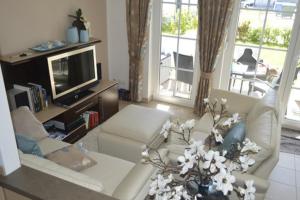 a living room with a couch and a tv at Ferienwohnung Gesine 2 in Nienhagen