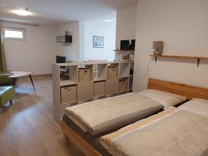 a room with two beds in a room with a table at Ferienwohnung Gartenweg in Strullendorf
