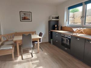 a kitchen with a wooden table and a table and chairs at Ferienwohnung Gartenweg in Strullendorf +3 photos