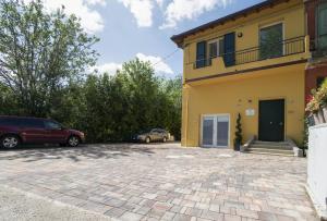 a house with two cars parked in a driveway at Casa del Falegname - Loft Abete con cucina in San Giovanni in Bosco
