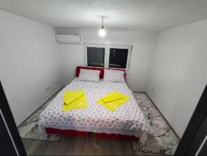a bedroom with a bed with two yellow pillows at Apartman Florida ranč in Doboj