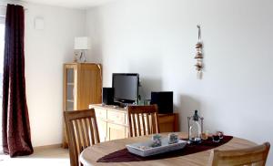 a dining room with a table with chairs and a tv at Jonas in Rerik