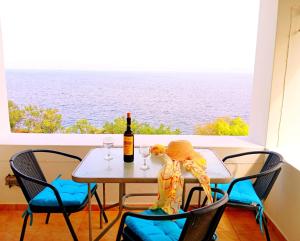 a table with a bottle of wine and some chairs at Patmos Garden Sea in Grikos