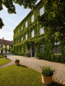 a building covered in ivy with plants in a yard at Schloss Hollenburg Aparte Apartments in Krems an der Donau