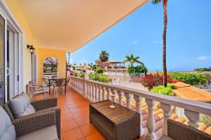 a balcony with a table and chairs and a view of the ocean at Spacious Villa Victoria Heated Pool in Callao Salvaje
