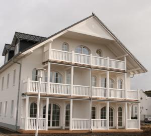 a large white house with a balcony at Gesine 3 in Nienhagen