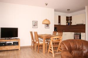 a kitchen and dining room with a table and chairs at Gesine 3 in Nienhagen +16 photos