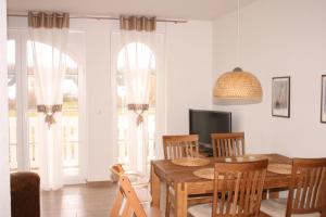 a dining room with a table and chairs and a television at Gesine 3 in Nienhagen