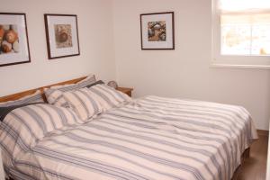 a bedroom with a bed with a striped comforter at Gesine 3 in Nienhagen