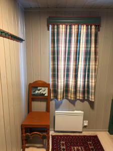 a room with a table and a chair and a window at Bakkestølveien 360 in Hol