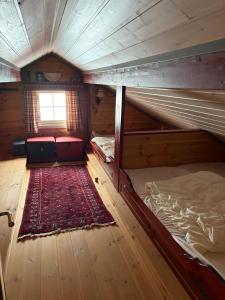 an attic room with two bunk beds and a rug at Bakkestølveien 360 in Hol +35 photos