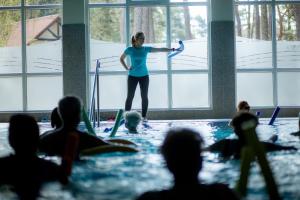 a woman standing in a swimming pool holding a paddle at Chimera Spa Niechorze in Niechorze +18 photos