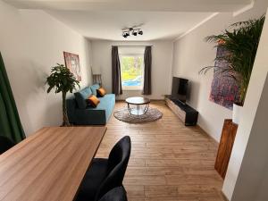 a living room with a blue couch and a table at Gartenwohnung im Kuhstall, Havelzugang, Vollausstattung in Ketzin