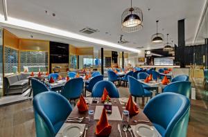 a restaurant with blue chairs and tables at Click collection Lucknow in Lucknow +13 photos