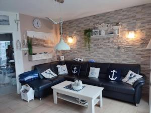 a living room with a black couch and a table at Fischers Fritze in Fehmarn