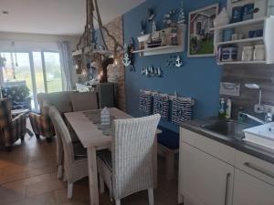 a kitchen with a table and chairs and a sink at Fischers Fritze in Fehmarn