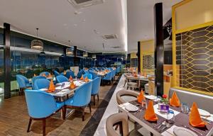 a dining room with tables and blue chairs at Click collection Lucknow in Lucknow