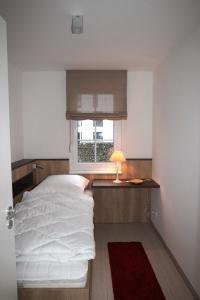 a small bedroom with a bed and a window at Dorothee 1 in Nienhagen