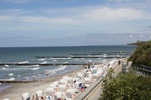 a beach with a bunch of chairs and the ocean at Dorothee 1 in Nienhagen