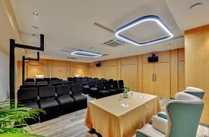 a conference room with a table and black chairs at Click collection Lucknow in Lucknow