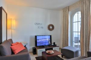 a living room with a couch and a flat screen tv at Gesine 4 Mare Baltic in Nienhagen +14 photos