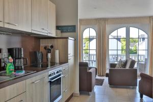 a kitchen with wooden cabinets and a living room at Gesine 4 Mare Baltic in Nienhagen
