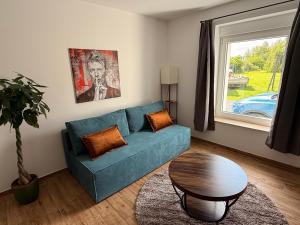 a living room with a blue couch and a table at Gartenwohnung im Kuhstall, Havelzugang, Vollausstattung in Ketzin