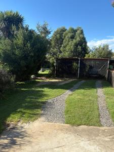 a backyard with a gate and grass and trees at 19 on Amber in Ugie